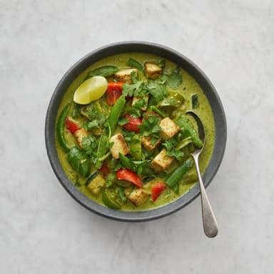 A bowl of green curry with vegetables